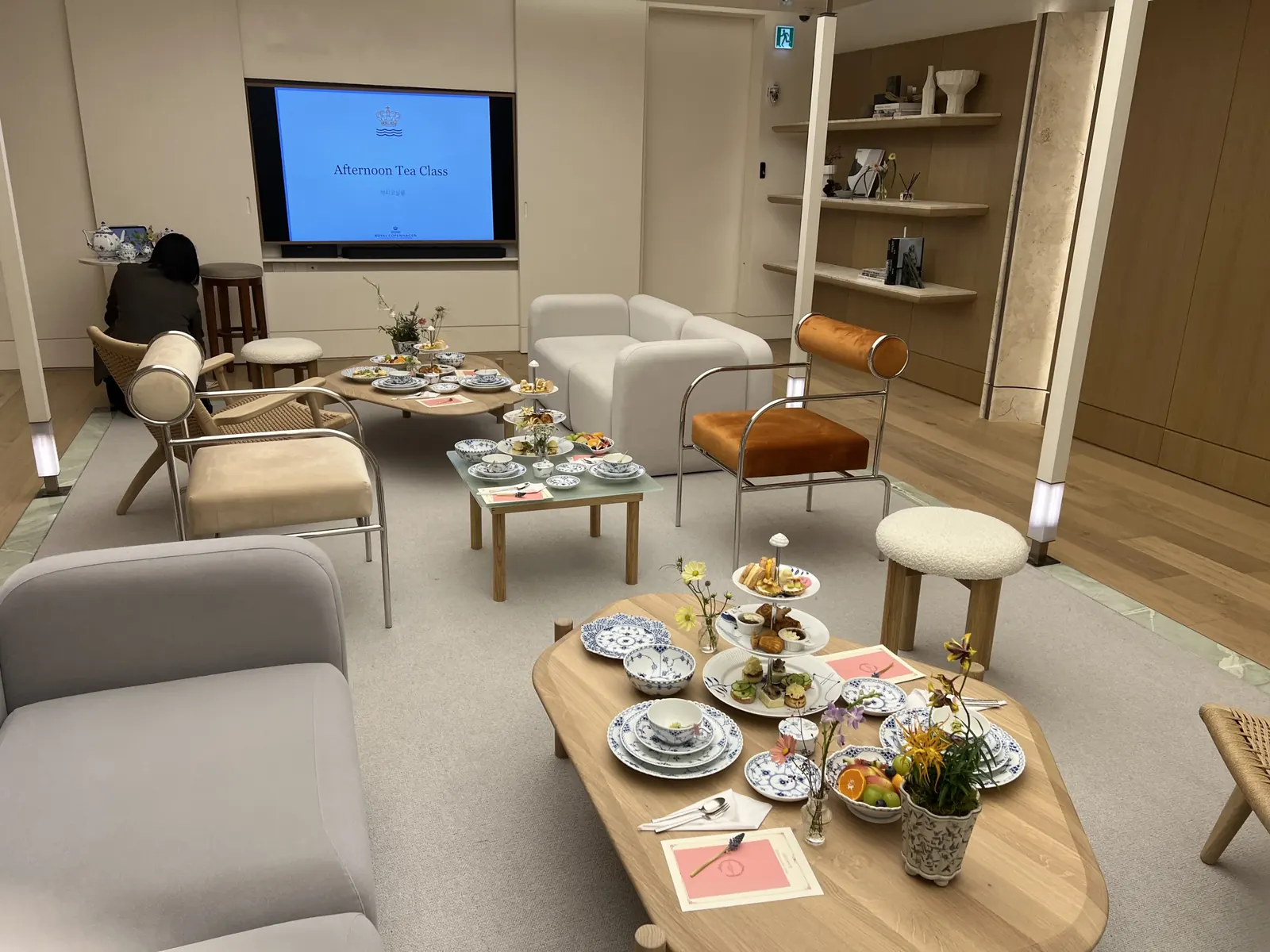 대형 TV에 'Afternoon Tea Class' 문구가 뜨고 라운지에 다과상이 다수 세팅된 전경