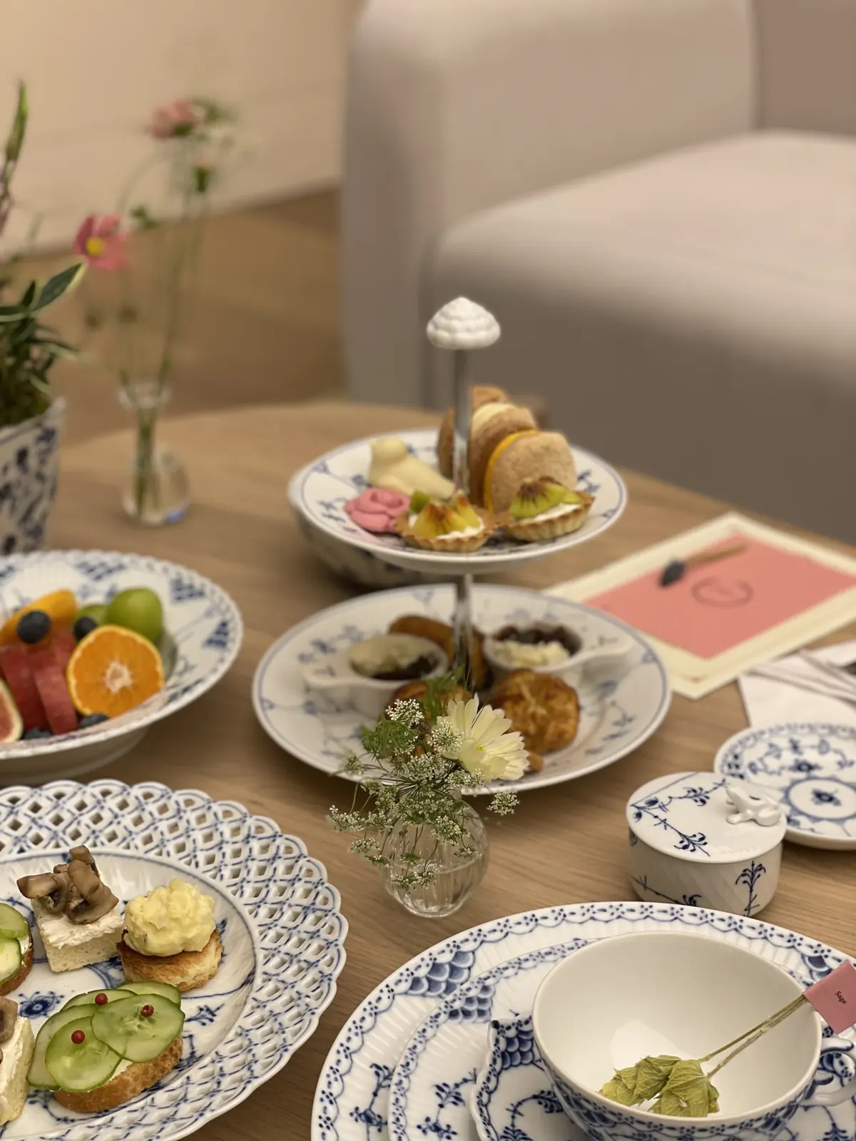 'Afternoon Tea Class' 안내 문구가 뜬 화면과 여러 테이블 다과상이 보이는 라운지 넓은 전경
