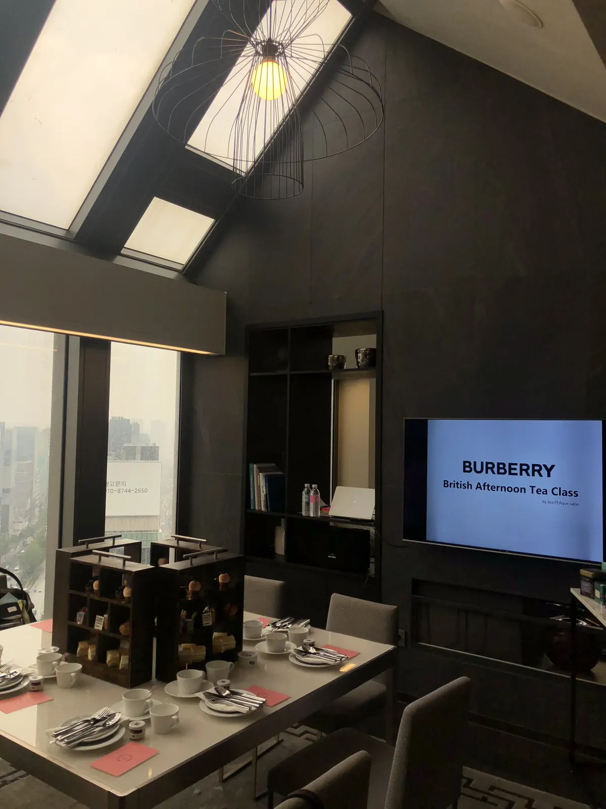 경사 천장 스위트룸 전경 — 다이닝 테이블과 배경 라운지 좌석까지 이어지는 넓은 구도