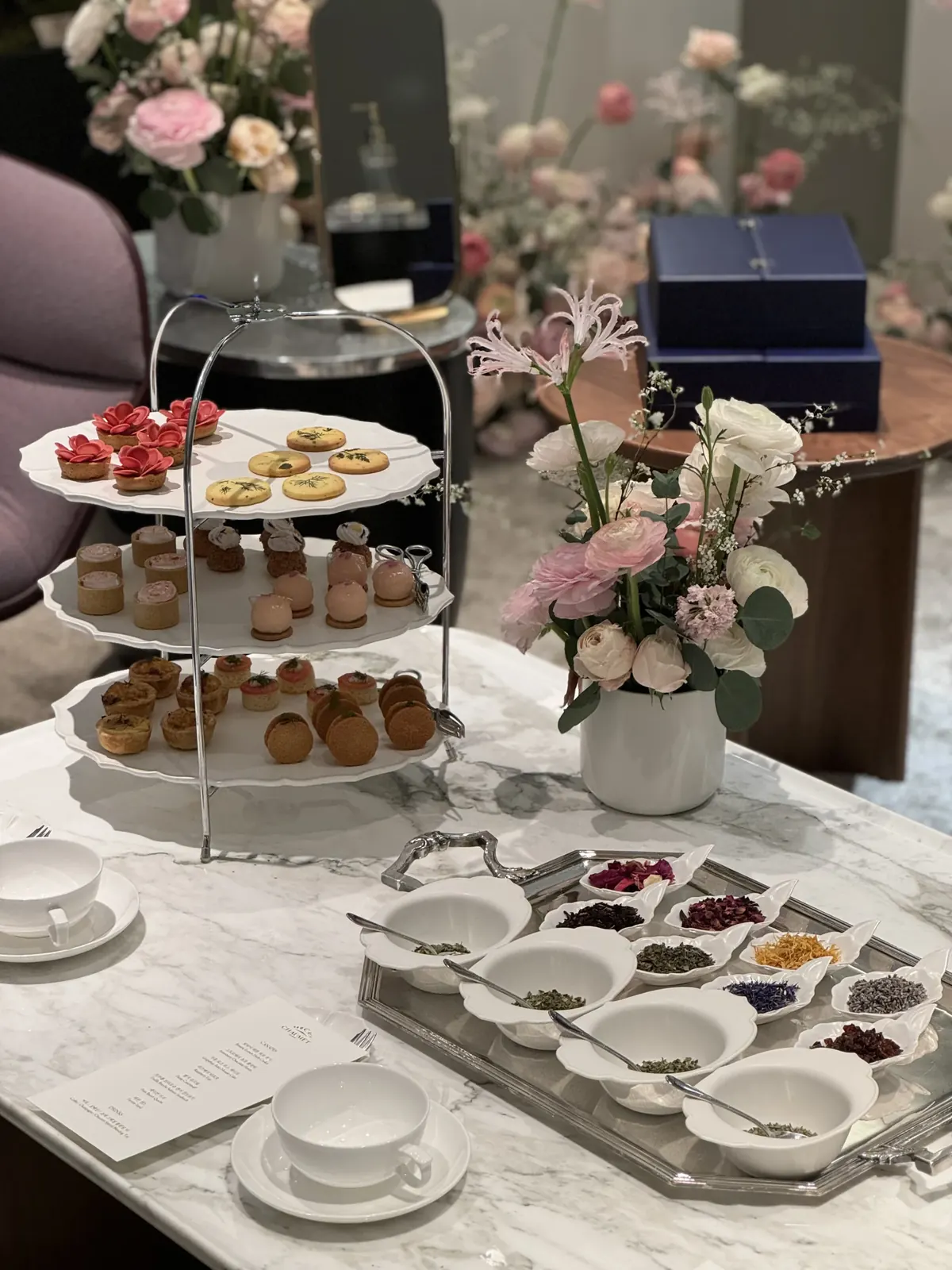 쇼메 신세계강남 VIP 라운지 와이드샷, 디저트 스탠드와 블렌딩 트레이가 꽃장식과 함께 세팅된 전경