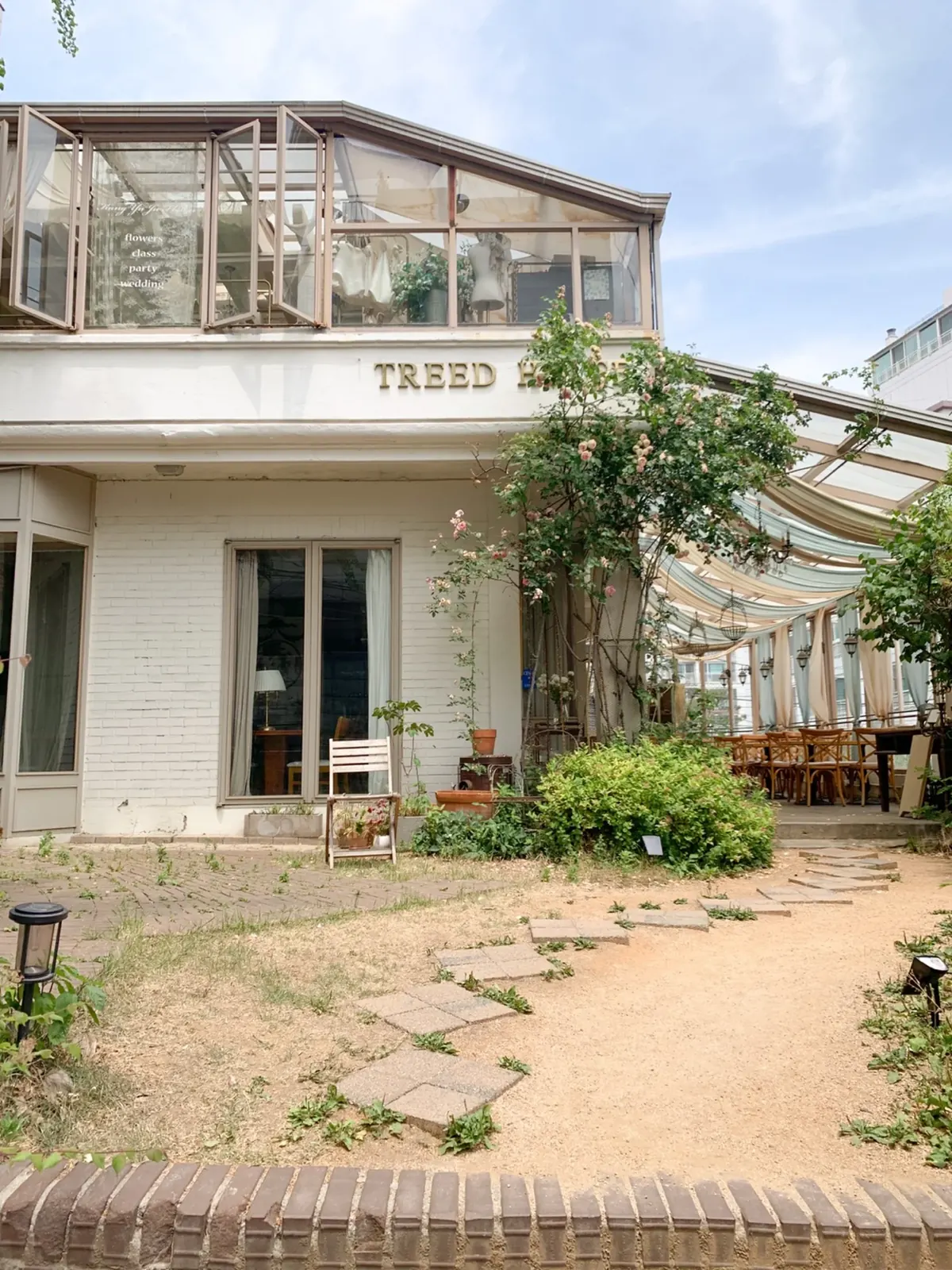 TREED HOUSE 간판과 장미 넝쿨이 있는 독립 매장 외관